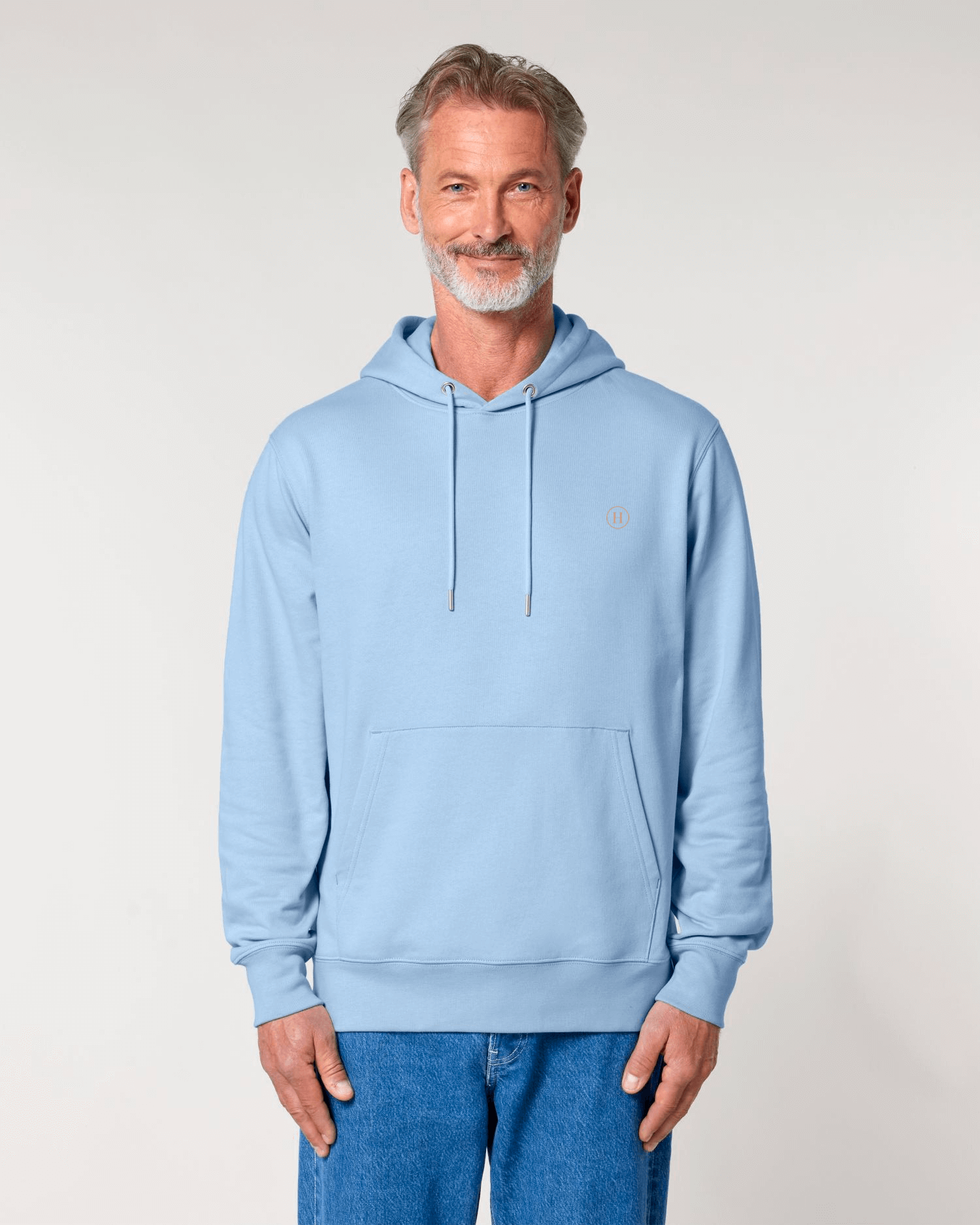Man wearing a light blue hoodie with a small logo on a plain background