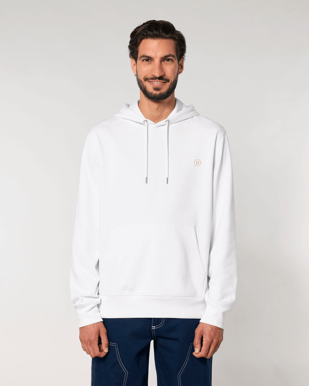 Man wearing a white hoodie with a small logo on a light gray background