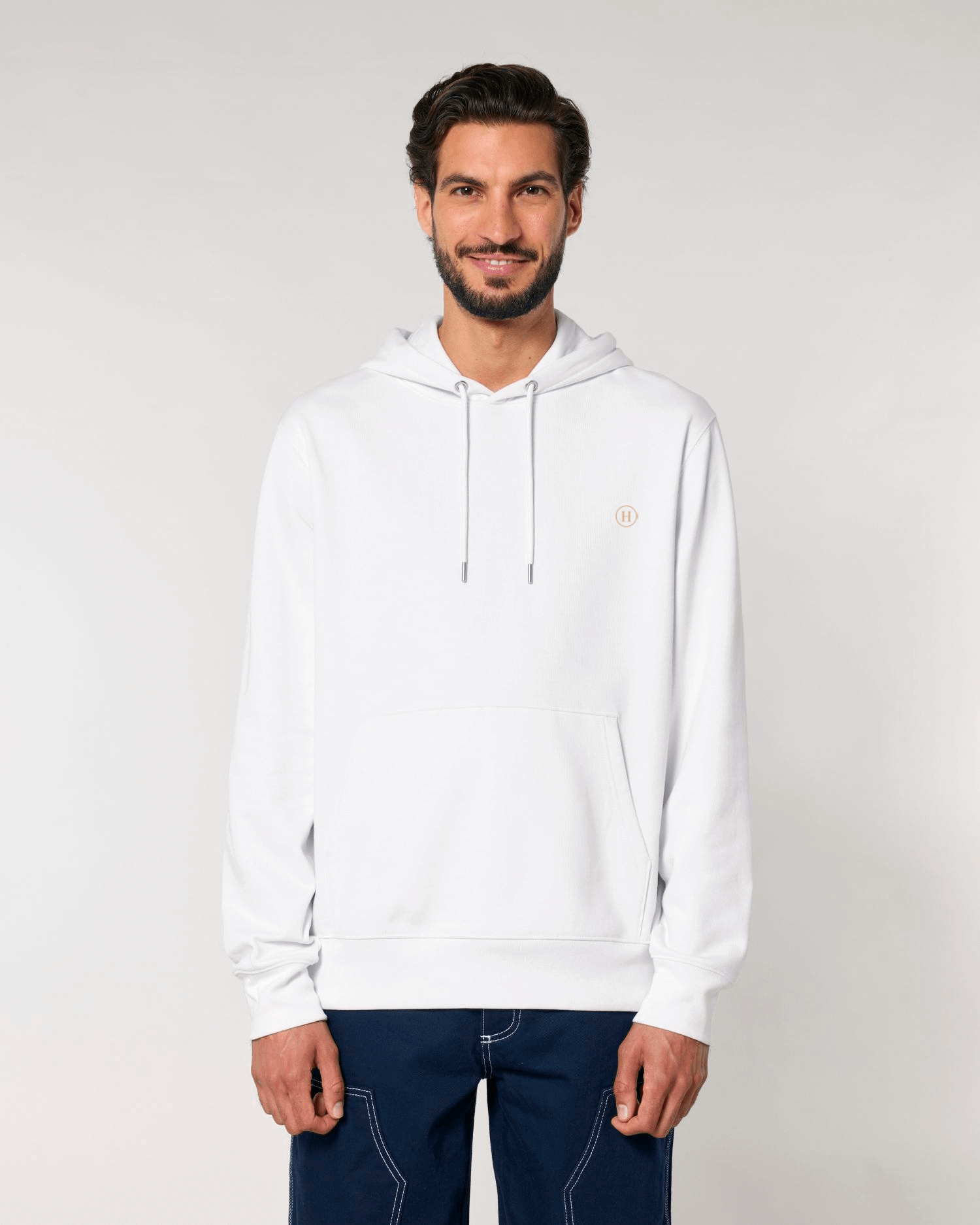Man wearing a white hoodie with a small logo on a light gray background