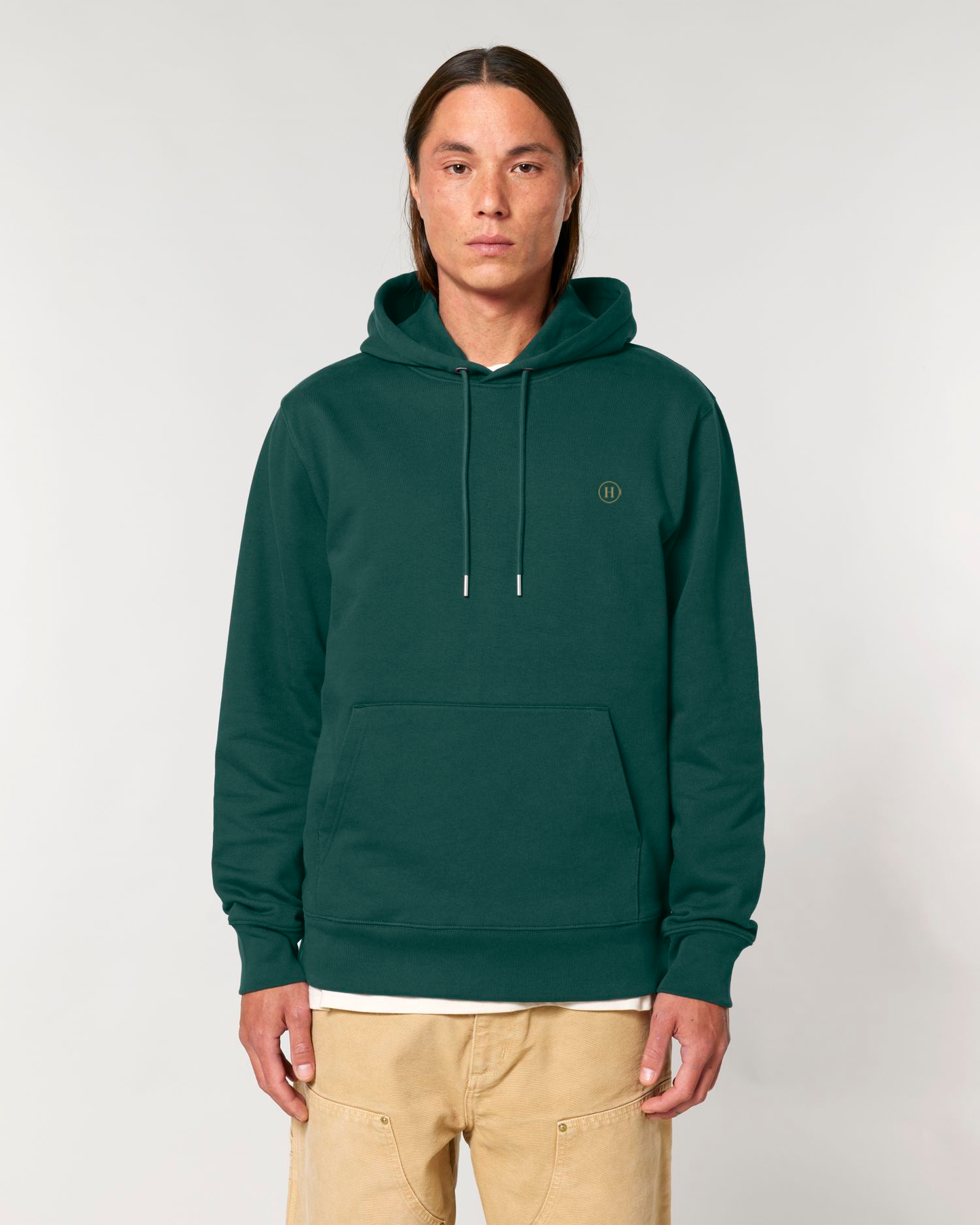 Person wearing a green hoodie with a small logo on a white background