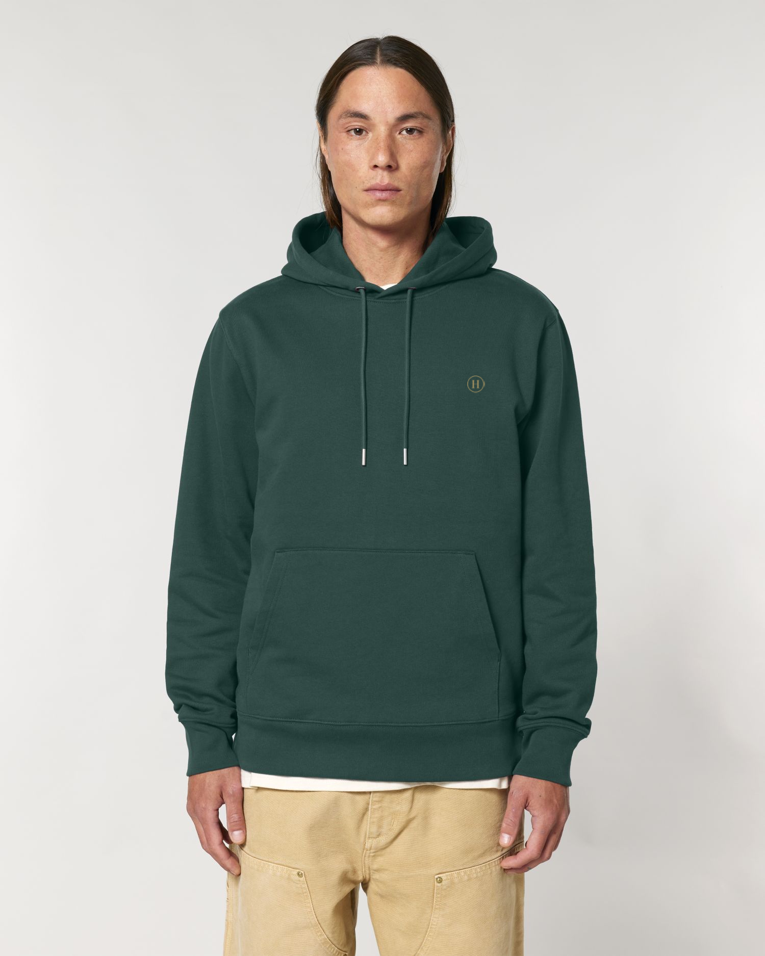 Person wearing a green hoodie with a small logo on a white background