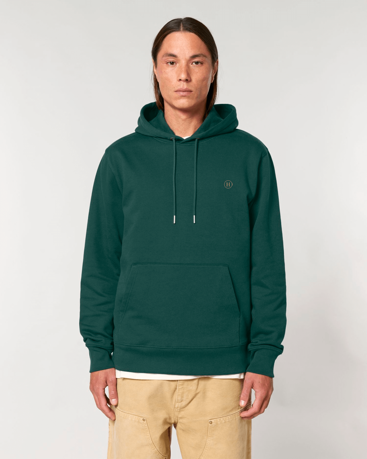 Person wearing a green hoodie with a small logo on a white background