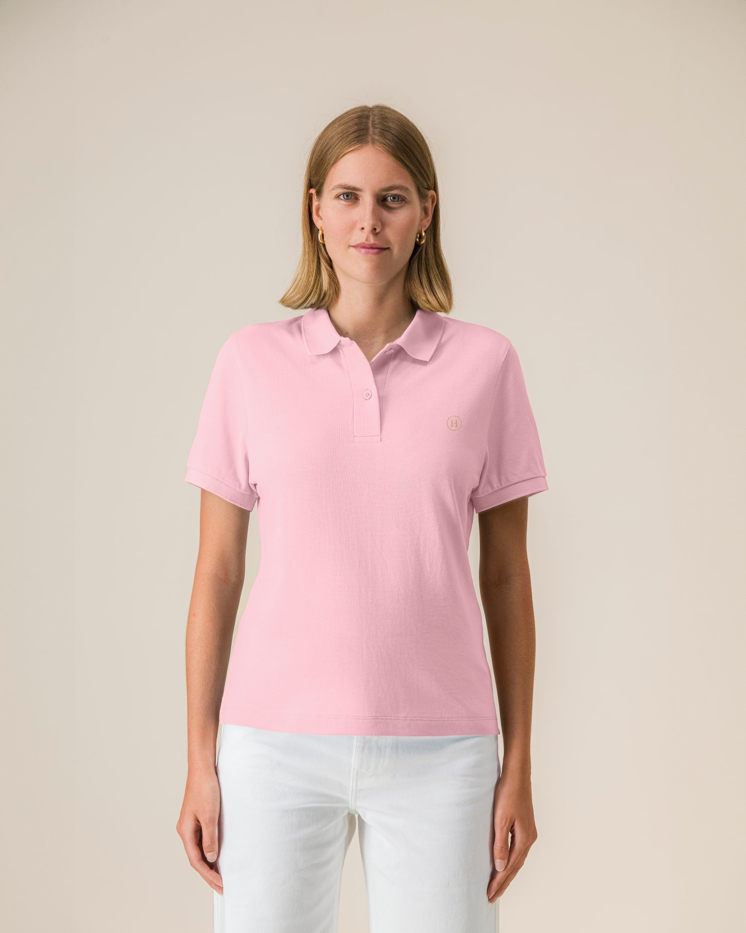 Woman wearing a pink polo shirt against a beige background