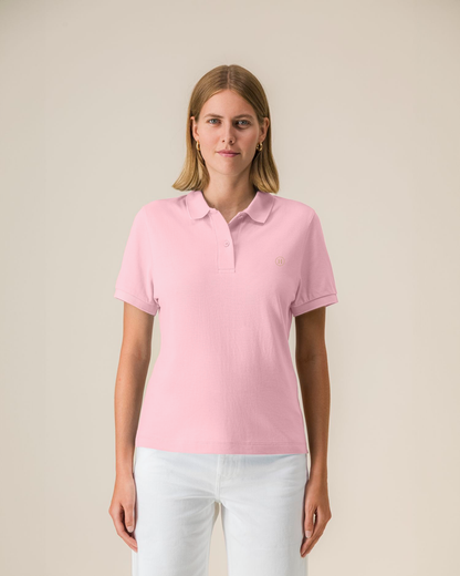 Woman wearing a pink polo shirt against a beige background