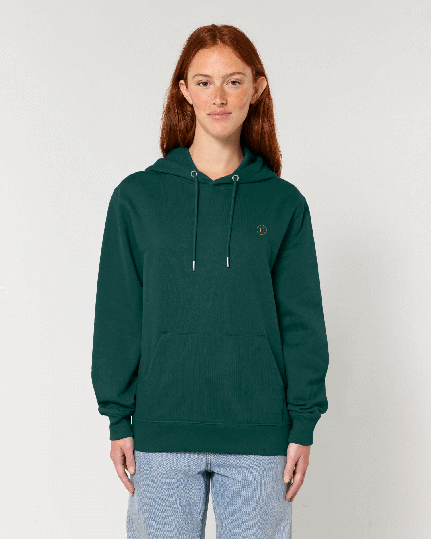 Person wearing a green hoodie with a logo on a plain background