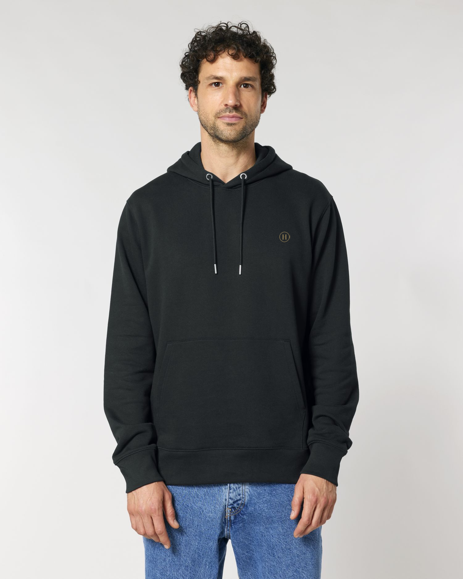 Man wearing a black hoodie with a small logo on a white background