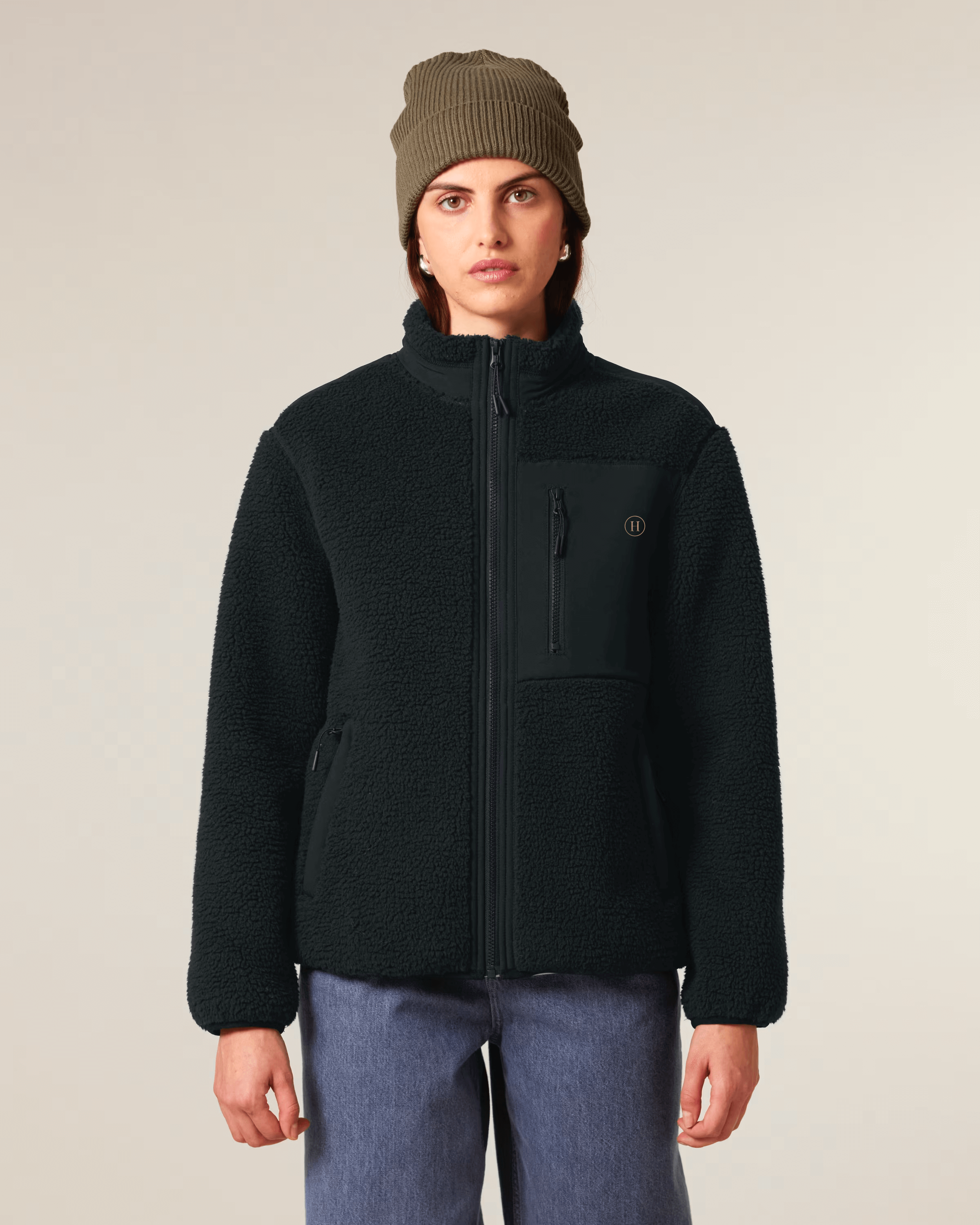 Person wearing a black jacket and green beanie on a plain background