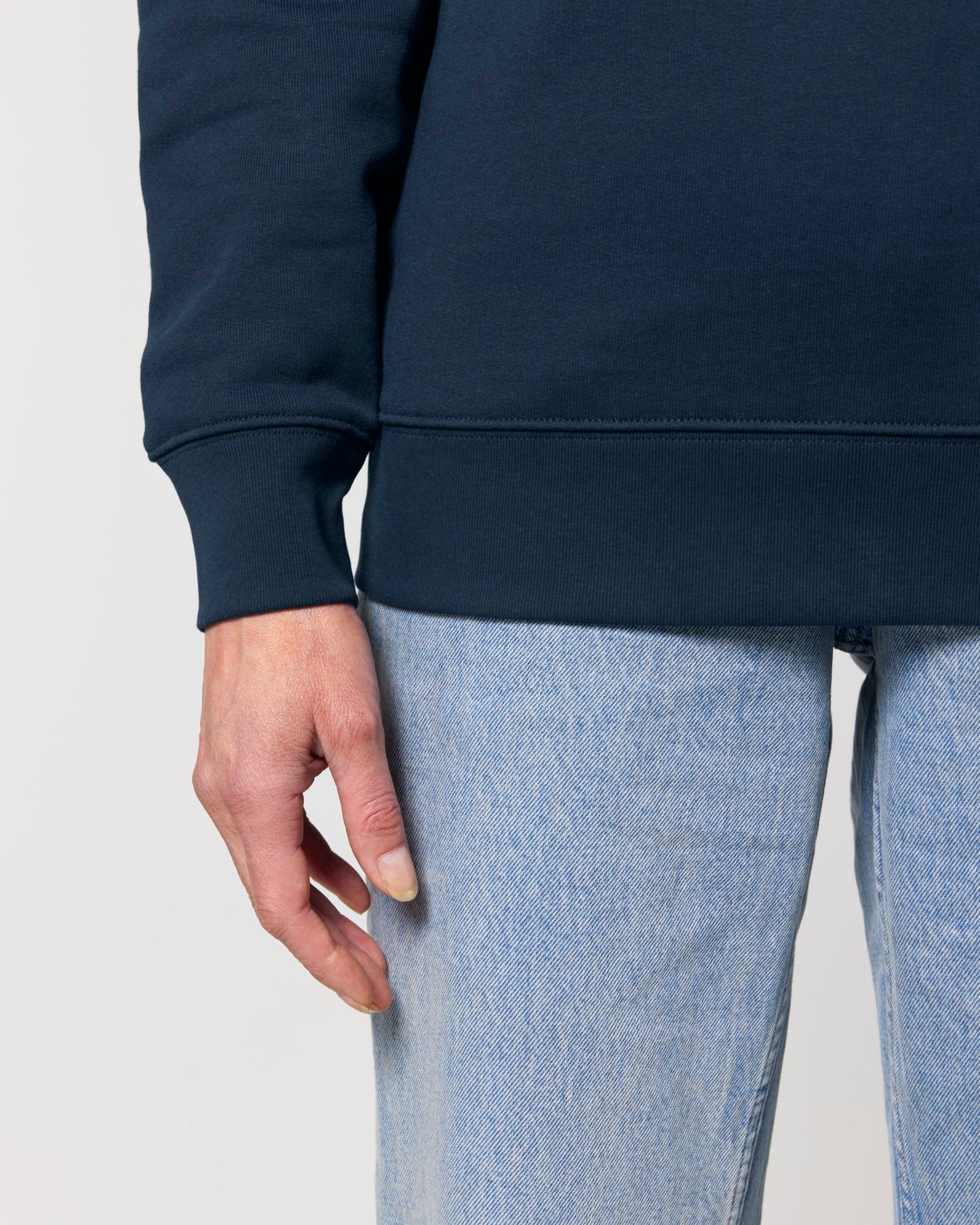 Navy blue sweatshirt and light blue jeans on a plain background