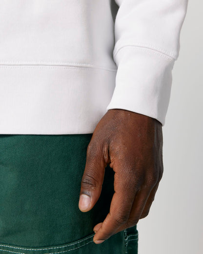 Hand wearing a white sweatshirt and green pants on a light gray background